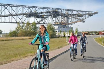 Eine Familie unternimmt eine Radtour um das Besucherbergwerk F60. Foto: Tourismusverband Lausitzer Seenland e.V., Nada Quenzel