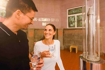 Trinkhalle in Bad Sulza: Junges Paar beim Verkosten der Trinksole, die als natürliches Heilmittel anerkannt ist. Foto: Saale-Unstrut-Tourismus e.V., Transmedial