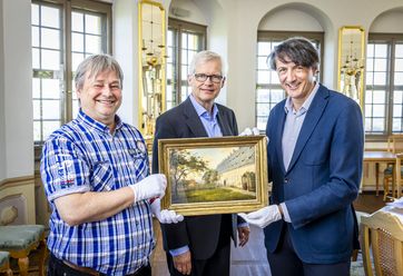 Andrej Pawluschkow (links im Bild), wissenschaftlicher Mitarbeiter der Festung Königstein und André Thieme (rechts im Bild), Geschäftsführer der Festung Königstein, nahmen heute von Christoph Großpietsch, einem Enkel des Sammlers Fritz Busche, das wertvolle Gemälde entgegen – Foto: Marko Förster/Festung Königstein gGmbH